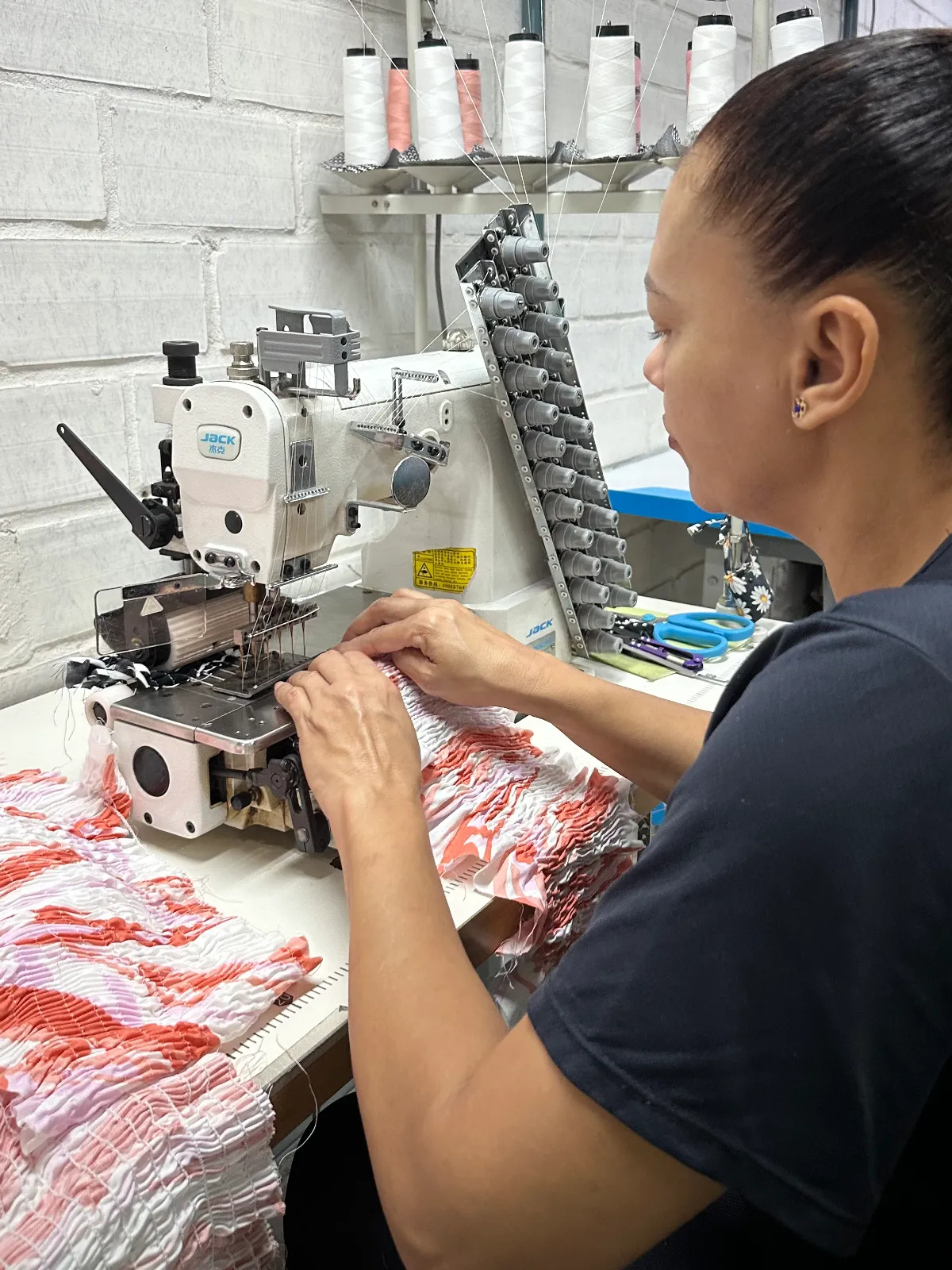 Costureira trabalhando em máquina de costura