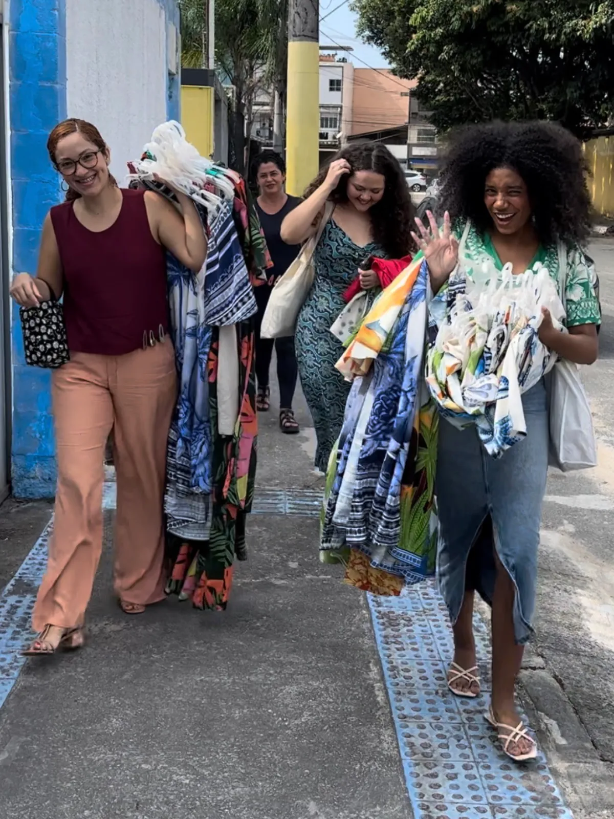 Estilistas caminhando com modelos carregando peças